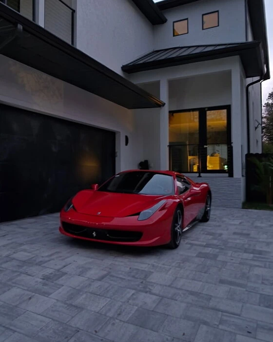 Red Ferrari 458 with tinted windows, photographed outside a Naples home after Tamiami’s window-tint installation
