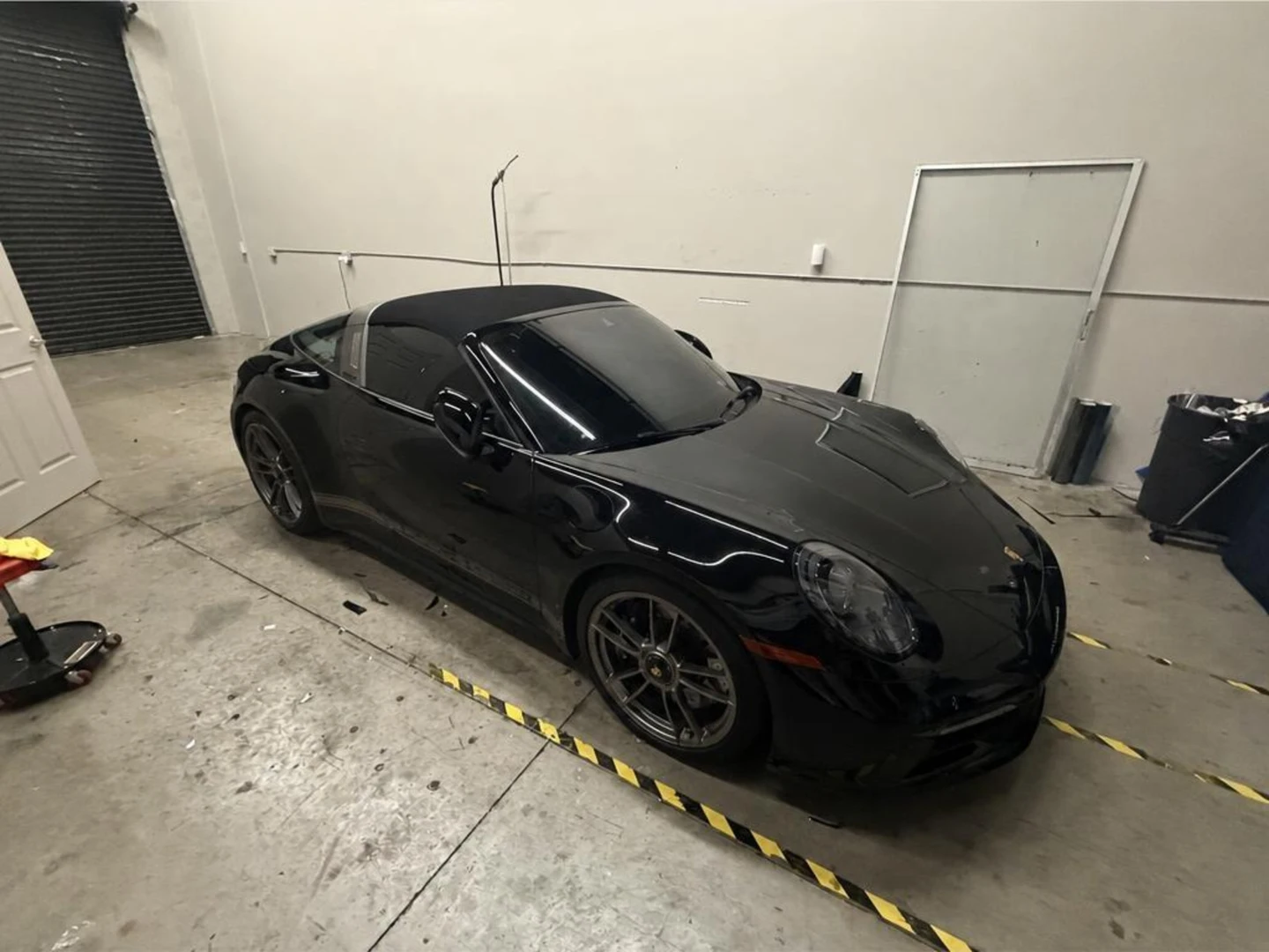 Black Porsche 911 Targa with tinted glass inside Tamiami’s Naples shop