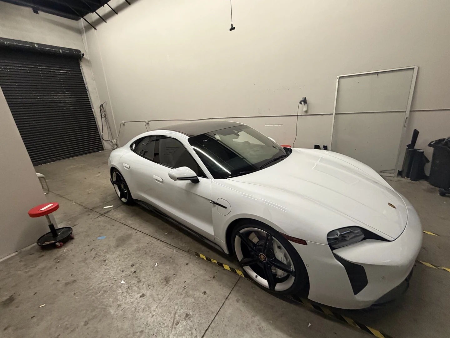 White Porsche Taycan with freshly tinted windows at Tamiami Tint of Naples